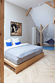 Wooden double bed in attic bedroom
