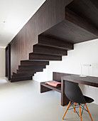 Desk below staircase boxed in with dark wood