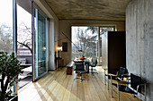 Maskuliner Designer-Wohnraum mit Betonwänden und Holzboden