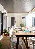Set wooden table on sunny roofed terrace