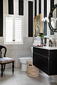 Washstand, toilet and upholstered chair in black-and-white bathroom