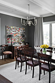 Dining table and chairs in dark wood in dining room with grey walls
