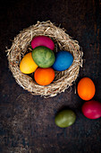 Easter eggs coloured with natural dyes in a nest