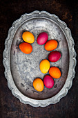 Easter eggs coloured with organic dyes on a pewter plate
