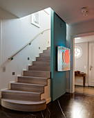 Licht-Kunst an blauer Wand vor der Treppe im Eingangsbereich