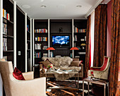 Shelves and velvet armchairs in small, classic living room