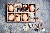 Brown Easter eggs with white motifs and Easter decorations in display case
