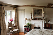 Schlafzimmer in englischem Landhaus mit niedriger Decke und Kamin