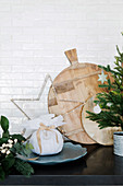Holzschneidebretter, Geschenk und weihnachtliche Deko vor weißer Fliesenwand