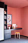 Curved red wall in the children's room with built-in desk