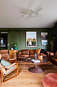 Wohnzimmer in Braun und Grün mit Ledersofas und Ledersesseln