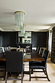 Formal dining room with black walls and art deco chandeliers