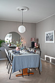 Set table in dining room in shades of grey with pink accents