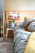 Scatter cushions on bed, bedside table and photo of children on wall