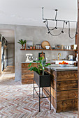 Stylische Küche mit Holzfront und Ziegelboden, moderne Lampe über Theke