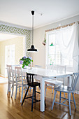 Black pendant lamp and vase of flowers in dining area