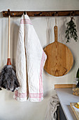 Feather duster, tea towel and chopping board hung from pegs