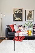 Colourful scatter cushions on leather sofa and glass table on white rug in living room