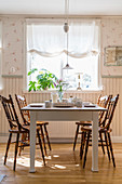 Chairs with turned legs and spindles around table in country-house-style dining room