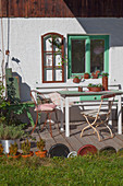 Rust-effect ornaments in seating area on terrace of farmhouse