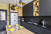 Black designer kitchen with central dining area