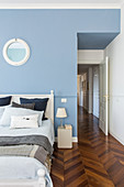 Bedroom with pale blue wall and herringbone parquet floor in period building
