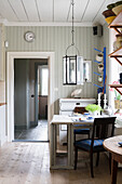 White, drop-leaf dining table below window in kitchen-dining room of renovated Swedish house