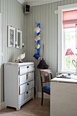 White chest of drawers and drop-leaf dining table in kitchen-dining room of Swedish house