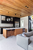 Moderner offener Wohnraum mit Holzdecke und Kücheninsel