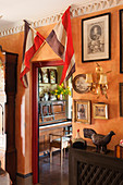 Two French flags above doorway leading into room with piano