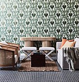 Safari-style seating area in front of green wallpaper with palm tree motifs