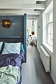 Bett vor blauer Trennwand in renoviertem holländischen Stadthaus