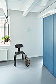 Black designer chair in open doorway next to blue partition