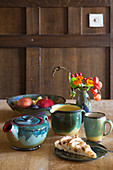 Ceramic vessels, apple tart and autumn posy on wooden table