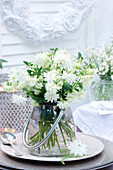 Bouquet of white aquilegia in polka-dot vase with handle