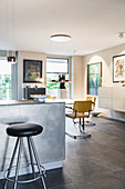 Breakfast bar and stool with dining area and artworks on wall in background