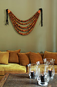 Sofa and wall hanging behind candle lanterns on coffee table