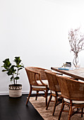 Rattan chairs around wooden table in dining room