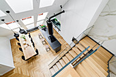 Blick auf Kücheninsel, Essbereich und Treppenaufgang in hohem Raum mit Dachschräge