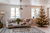 Decorated Christmas tree, pale couch and coffee table in living room
