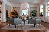 Christmas tree and blue armchairs in elegant living room