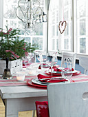 Table festively set in red and white in conservatory