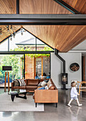 Living room with a leather corner sofa under a wood-clad pointed roof