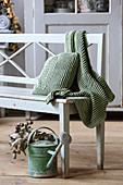 Knitted, ribbed cushion and blanket in autumnal green