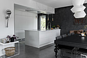 White island counter and black dining table in modern, open-plan kitchen