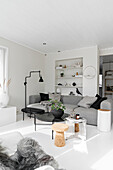 Pale grey couch and black side table in light-flooded white interior