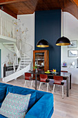 Blue velvet sofa, table in dining area and antique dresser in maisonette apartment