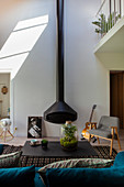 Suspended fireplace with double-height stove pipe in maisonette apartment