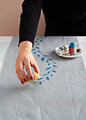 Printing a pattern on a tablecloth runner using a potato stamp