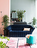 Dark blue velvet sofa in loft apartment with walls in pastel tones